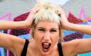 blonde girl holding head and screaming